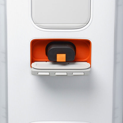 Close-up of a suitcase’s built-in orange compartment holding a JBL PartyBox Club 120 160W Wireless Party Speaker (White) with an orange button, plus a fold-out panel below featuring three white wireless speaker control buttons.